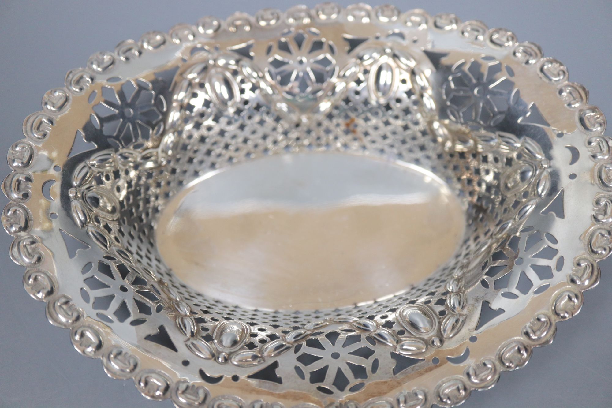 A late Victorian repousse silver bon bon dish and two similar Edwardian dishes, largest 16.8cm, 159 grams.